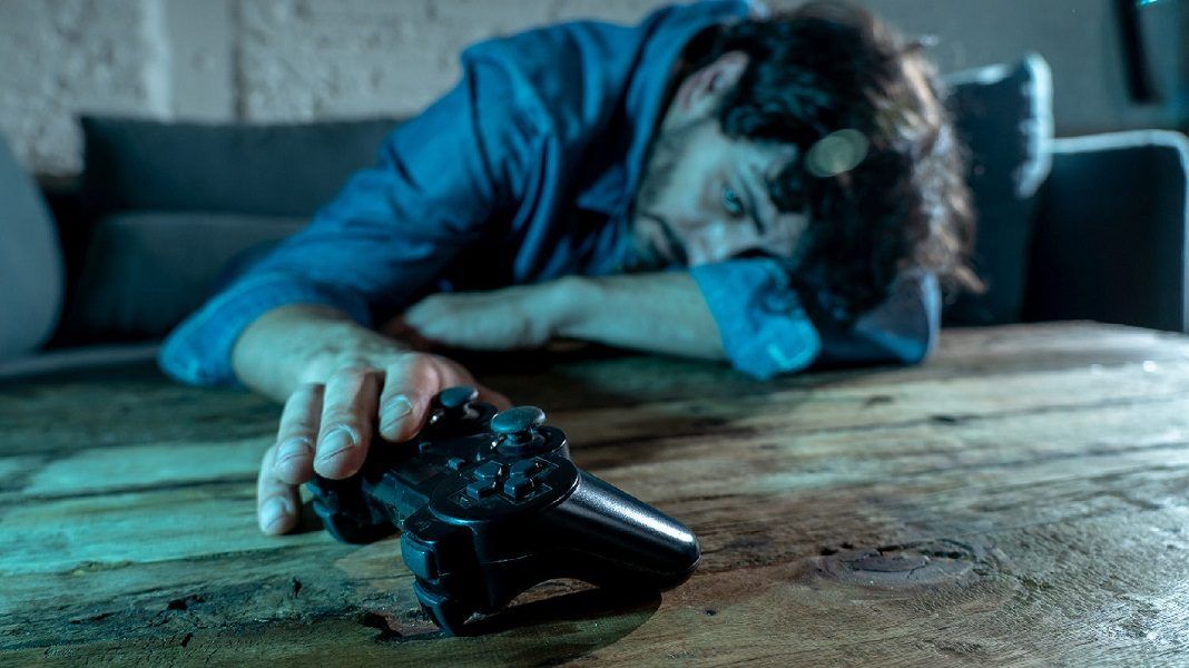 Addiction and dependency concept. close up on young mans hand with pad joystick playing video games Male addicted to console gaming concept.